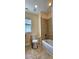 Neutral tiled bathroom with a standard bathtub and commode at 5905 Brookside Oak Cir, Norcross, GA 30093