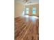 Large bedroom with hardwood floors, ample natural light, and a modern ceiling fan at 5905 Brookside Oak Cir, Norcross, GA 30093