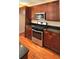 Kitchen features stainless steel appliances, granite countertops and dark wood cabinetry at 5905 Brookside Oak Cir, Norcross, GA 30093