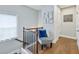 Bright hallway features hardwood floors, wood and iron railing, and decorative chair at 1165 Millennium Park Rd, Decatur, GA 30033