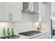 Close-up of a modern kitchen featuring stainless steel appliances, gas range, and white tiled backsplash at 1165 Millennium Park Rd, Decatur, GA 30033
