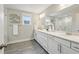 Bright bathroom has double sink vanity, tiled floors, and large mirror at 1165 Millennium Park Rd, Decatur, GA 30033