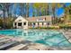 Community pool area surrounded by trees, featuring lounge chairs and umbrellas for relaxation at 1165 Millennium Park Rd, Decatur, GA 30033