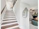 Elegant staircase featuring hardwood treads, white risers, and a stylish mirror that adds depth to the entryway at 1165 Millennium Park Rd, Decatur, GA 30033