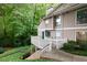 Exterior view of a tan condo featuring a porch with a railing and lush landscaping at 1501 Wynnes Ridge Cir, Marietta, GA 30067