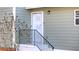 Home featuring a charming entrance with a well-lit doorway, black handrail, and tasteful exterior details at 2020 Kenwood Se Pl, Smyrna, GA 30082