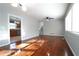 Bright room with hardwood floors, neutral walls, a ceiling fan, and a large window near the adjacent kitchen at 2020 Kenwood Se Pl, Smyrna, GA 30082