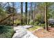Landscaped backyard with a concrete patio surrounded by lush trees and a serene atmosphere at 2049 Castleway Ne Ln, Atlanta, GA 30345