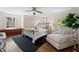 Bright bedroom features hardwood floors, a ceiling fan, a lounge chair, and large windows with shutters at 2049 Castleway Ne Ln, Atlanta, GA 30345
