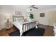 Well-lit bedroom boasts hardwood floors, ceiling fan, a lounge chair, and decor at 2049 Castleway Ne Ln, Atlanta, GA 30345