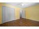 Bedroom with hardwood floors, a ceiling fan, closet doors, and bright yellow walls at 2049 Castleway Ne Ln, Atlanta, GA 30345