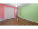Bedroom with closet, ceiling fan, and hardwood floors; walls are light green and light red at 2049 Castleway Ne Ln, Atlanta, GA 30345