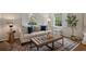 Living room with windows, hardwood floors, decorative rug, neutral color scheme and tufted leather ottoman at 2049 Castleway Ne Ln, Atlanta, GA 30345