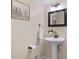 Powder room with pedestal sink, decorative mirror, and neutral color scheme at 2049 Castleway Ne Ln, Atlanta, GA 30345