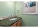 Powder room featuring a granite countertop, light green walls, and a window at 2049 Castleway Ne Ln, Atlanta, GA 30345