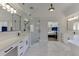 A spacious bathroom boasts marble floors, double sinks, a glass shower, and a view into an adjacent bedroom at 2546 Summer Song Way, Buford, GA 30519