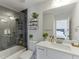 This bathroom has a tiled shower, modern fixtures, and a vanity with shelving for a clean aesthetic at 2546 Summer Song Way, Buford, GA 30519