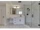 A modern bathroom features a glass shower with black hardware, a vanity with drawers, and marble floors at 2546 Summer Song Way, Buford, GA 30519