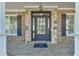 Elegant front entrance with a detailed glass door, stone accents, and a covered porch area at 2546 Summer Song Way, Buford, GA 30519