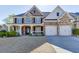 Charming two-story home features a stone and brick facade, a welcoming porch, and a manicured front yard at 2546 Summer Song Way, Buford, GA 30519