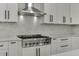 Bright kitchen features stainless steel range, hood, and marble subway tile backsplash at 2546 Summer Song Way, Buford, GA 30519