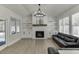 Sunlit living room offers a fireplace, built-in shelves, and vinyl plank flooring at 2546 Summer Song Way, Buford, GA 30519