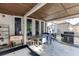 This covered patio features a dark wood ceiling, outdoor furniture, and a grill at 2546 Summer Song Way, Buford, GA 30519