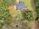 Aerial perspective of a home surrounded by lush trees, green lawn, and a fire pit at 1202 Coan Dr, Locust Grove, GA 30248