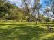 Expansive lush backyard featuring mature trees, a chair, and a swing set at 1202 Coan Dr, Locust Grove, GA 30248