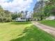 A quaint one-story home with a gravel driveway, a carport, and a well-manicured lawn at 1202 Coan Dr, Locust Grove, GA 30248