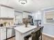 A modern kitchen with white cabinets, stainless steel appliances, and an island with seating at 1202 Coan Dr, Locust Grove, GA 30248
