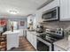 A modern kitchen with white cabinets, stainless steel appliances, and granite countertops at 1202 Coan Dr, Locust Grove, GA 30248