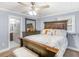 Cozy main bedroom with ceiling fan, a wooden bedframe, and ensuite bathroom at 1202 Coan Dr, Locust Grove, GA 30248