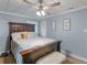 Comfortable main bedroom with a wooden bedframe, ceiling fan and neutral decor at 1202 Coan Dr, Locust Grove, GA 30248