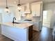 Island kitchen with quartz countertops, dark hardware, stainless steel appliances and pendant lighting at 1826 Butterfly Way, Marietta, GA 30066