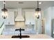 Bright kitchen features white cabinets, quartz countertops, stylish backsplash and pendant lighting at 1826 Butterfly Way, Marietta, GA 30066