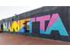 Colorful graffiti-style mural on a brick wall, adding a unique and vibrant artistic touch to the urban landscape at 1826 Butterfly Way, Marietta, GA 30066