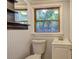 Compact bathroom featuring a modern sink, toilet, wood trim and an adjacent mirror and shelves at 2270 Cresta Dr, Decatur, GA 30032