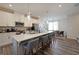 Modern kitchen featuring white cabinets, stainless steel appliances, a large island with seating, and pendant lighting at 3323 Owl Creek Pkwy, Acworth, GA 30102