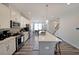 Modern kitchen featuring stainless steel appliances, white cabinetry, a large island, and open layout to the dining area at 3323 Owl Creek Pkwy, Acworth, GA 30102