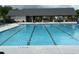 Residential community swimming pool with several swim lanes under a large pavilion near lounge chairs and tables at 3323 Owl Creek Pkwy, Acworth, GA 30102