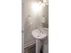 A well-lit, neutral-toned powder room with a pedestal sink, modern faucet, and decorative towel ring at 3323 Owl Creek Pkwy, Acworth, GA 30102