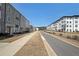 Street view of modern townhomes with well-manicured lawns, neat sidewalks, and beautiful landscaping under a clear blue sky at 3323 Owl Creek Pkwy, Acworth, GA 30102