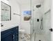 Stylish bathroom featuring a blue vanity, glass-enclosed shower with modern fixtures, and patterned floor tiles at 1385 Benteen Se Way, Atlanta, GA 30315