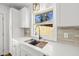 White cabinets, quartz countertops, and stainless steel faucet in a modern kitchen overlooking the backyard at 1385 Benteen Se Way, Atlanta, GA 30315