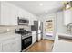 Well-appointed kitchen boasts stainless appliances, white cabinets, quartz counters, and a convenient exterior door at 1385 Benteen Se Way, Atlanta, GA 30315