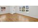 Bright, empty living room featuring hardwood floors, fresh white walls, and large windows with neighborhood views at 1385 Benteen Se Way, Atlanta, GA 30315