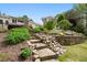 Beautifully landscaped backyard with stone steps, retaining wall, and lush greenery at 1724 Ridge Valley Nw Ct, Atlanta, GA 30327