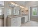 Bright bathroom featuring double vanity, granite counters, and large mirrors with decorative lighting at 1724 Ridge Valley Nw Ct, Atlanta, GA 30327
