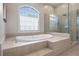 Modern bathroom featuring a soaking tub with tile surround and frameless glass shower at 1724 Ridge Valley Nw Ct, Atlanta, GA 30327